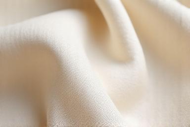 Gros plan d'un tissu de lin européen texturé, de couleur écrue et naturelle.