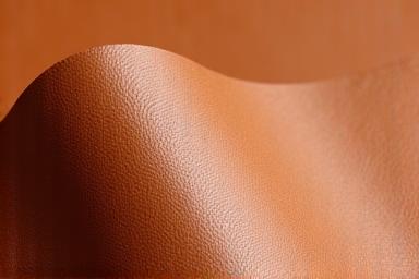 Texture du Piñatex, un cuir végétal fait à partir de fibres de feuilles d'ananas, de couleur marron clair.